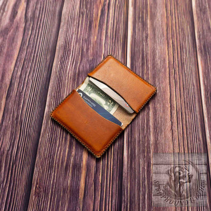 photo of wood grain background with a walnut leather wallet shown open with credit cards and cash