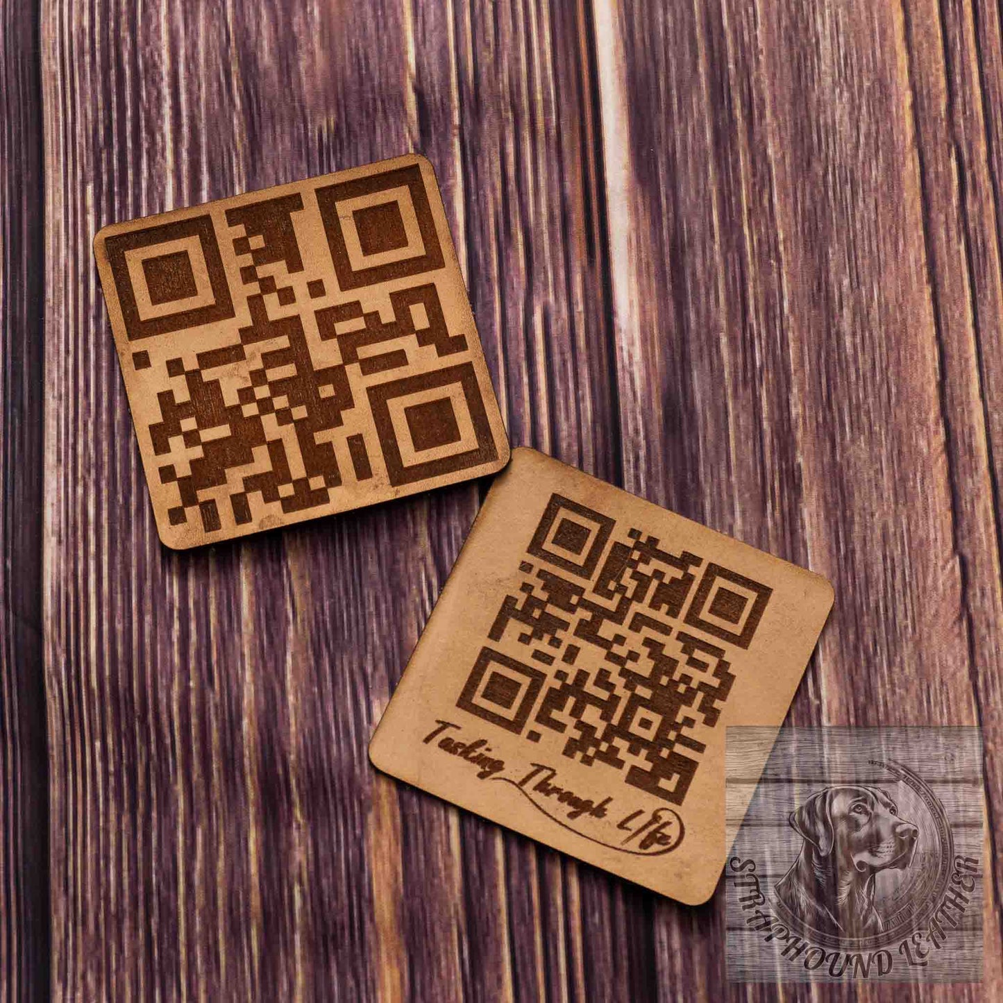 photo showing two coasters in a natural leather with a QR scan-able code laser engraved on them on a wood grain background. 