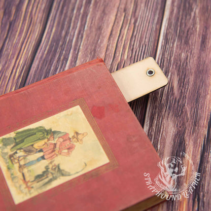 leather bookmark in a book on a woodgrain background.